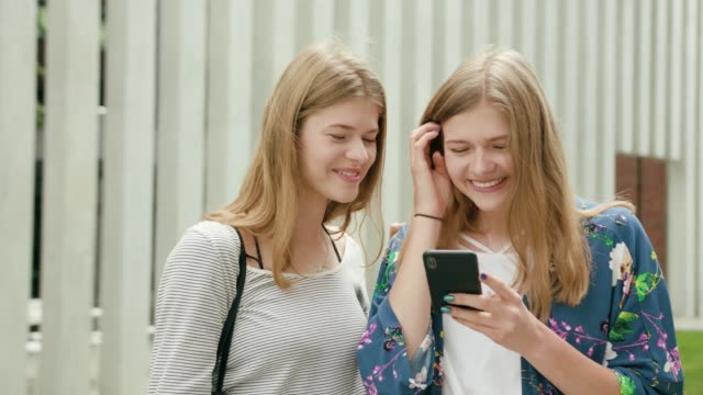 Young-Ladies-Using-a-Phone-in-Town