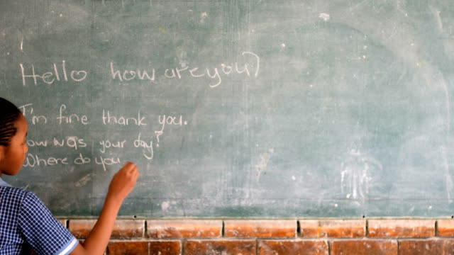 Schoolgirl-writing-on-chalkboard-in-classroom-4k