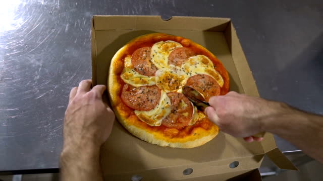 Chef-de-hombre-corta-el-delicioso-caliente-y-deliciosa-pizza-de-cerca