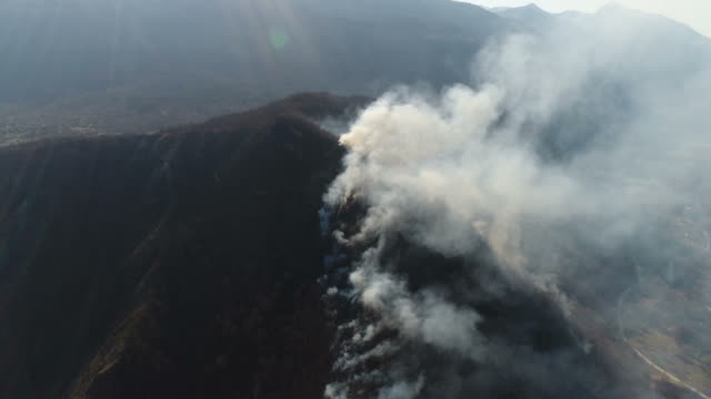Aerial-footage-of-a-mountain-covered-in-thick-smoke...
