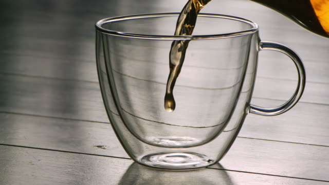 Hot-tea-being-poured-into-glass-in-slowmotion