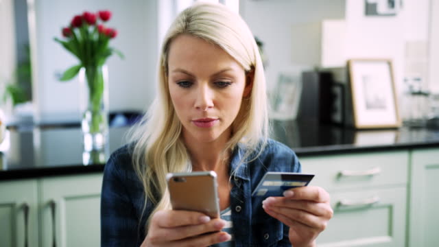 Schöne-blonde-Frau,-die-Eingabe-von-Kreditkartendaten-in-Smartphone