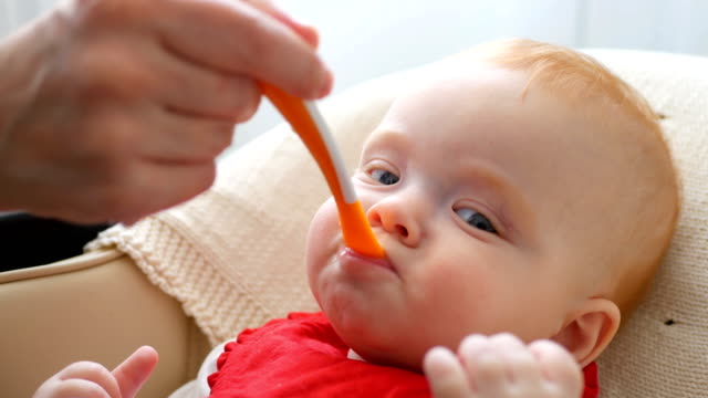 Mother-gives-baby-food-from-a-spoon