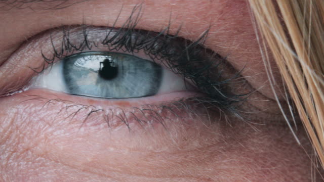 Blaues-Auge-einer-Frau,-die-Licht-und-Blinking-reflektiert