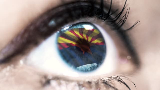 Frau-blaues-Auge-in-Nahaufnahme-mit-der-Flagge-von-Arizona-Staat-in-Iris,-vereinigte-Staaten-von-Amerika-mit-Windbewegung.-Videokonzept