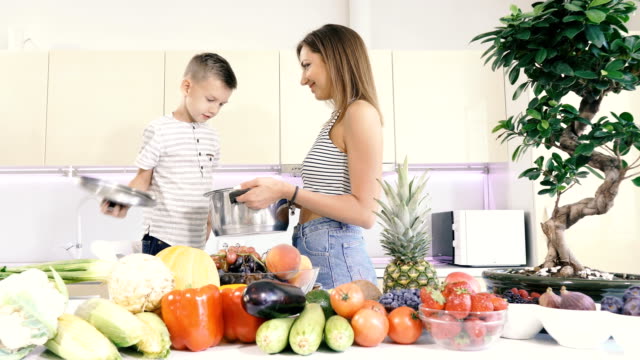 Kitchen-and-food.-Mom-and-son-are-holding-a-pot-for-cooking.