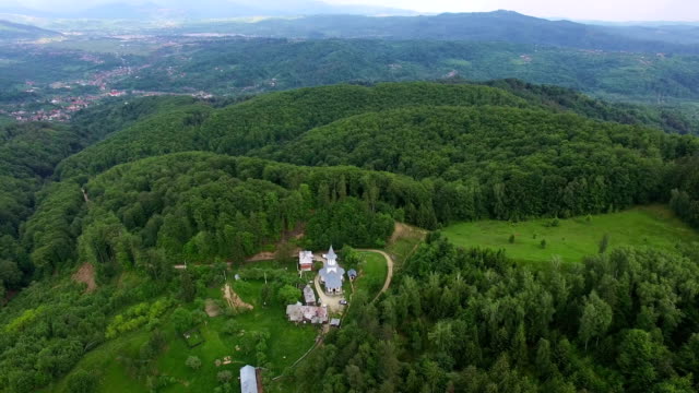 Christian-church-on-top-of-green-hill,-aerial-view