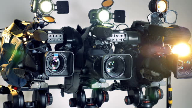 Three-working-video-cameras-in-a-slow-rotating-shot.