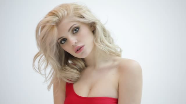 Sexy-schöne-blonde-Frau-posiert-in-roten-Badeanzug-im-weißen-studio
