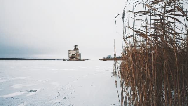 Ruined-church-building-in-middle-of-frozen-lake-covered-in-snow