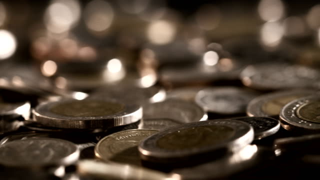 Close-up-money-coin-stacking-on--the-floor-in-dark-light-,-business-and-financial-for-money-saving-or-investment-background-concept--,-extremely-close-up-and-shallow-DOF
