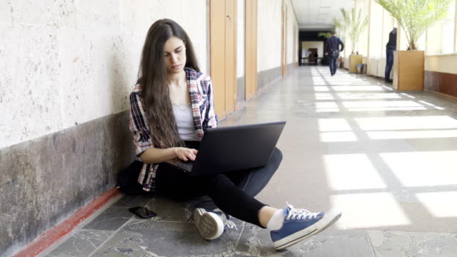 Mädchen-mit-Laptop-in-einem-College-Korridor