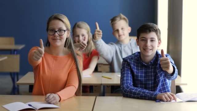 students-showing-thumbs-up-on-lesson-at-school