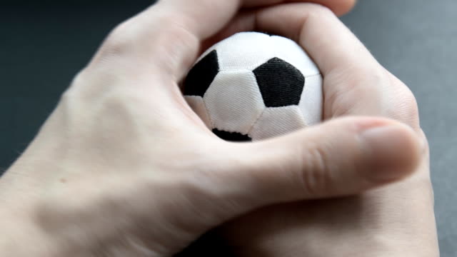 Hand-drückt-einen-kleinen-Fußball.