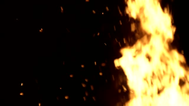 Burning-ash-rise-from-large-fire-in-black-background