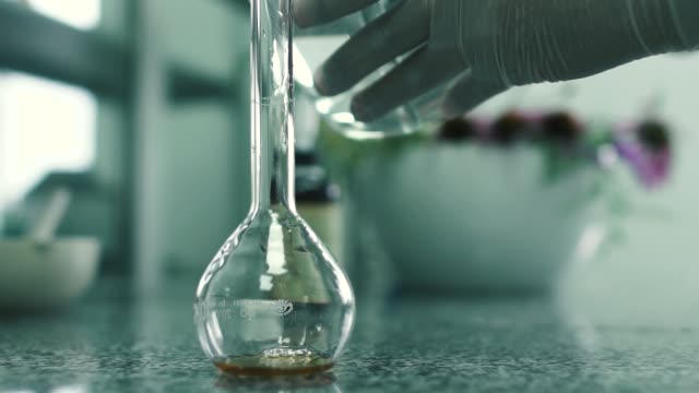 Laboratory-assistant-pours-the-water-into-the-flask