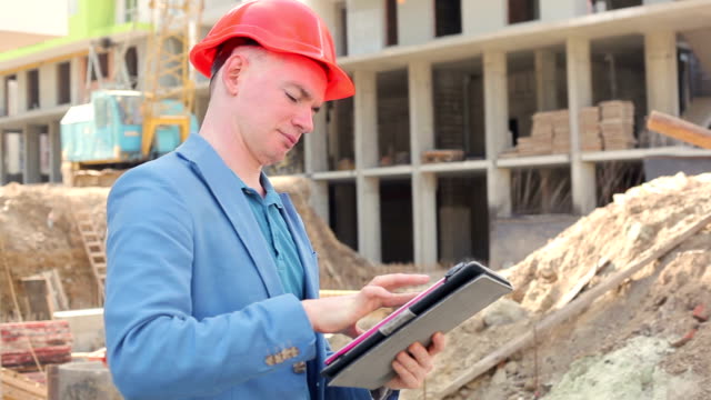 a-young-architect-working-on-a-tablet-near-the-construction-site