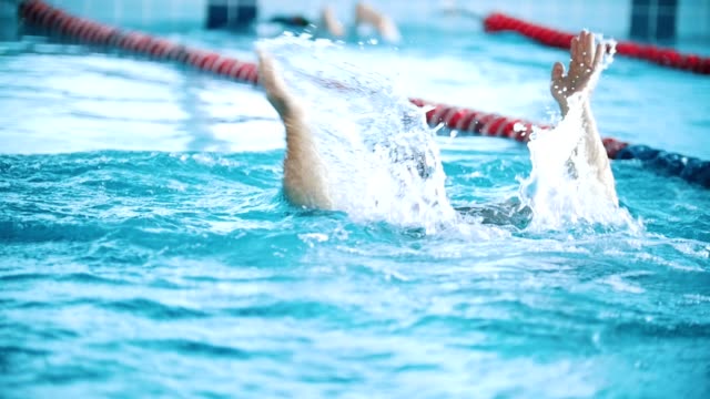 Behinderte-Mensch-schwimmt-auf-der-Rückseite-in-einem-Schwimmbad.-Slow-Motion.-Der-Schmetterling-Strich.