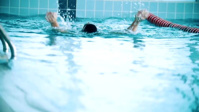 Behinderte-Mensch-schwimmt-auf-der-Rückseite-in-einem-Schwimmbad.-Slow-motion