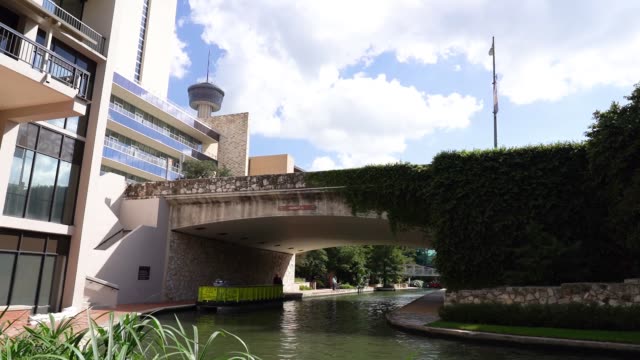 San-Antonio-River-Walk-Boote-und-Gebäude-mit-Turm-im-Hintergrund-Zeitraffer