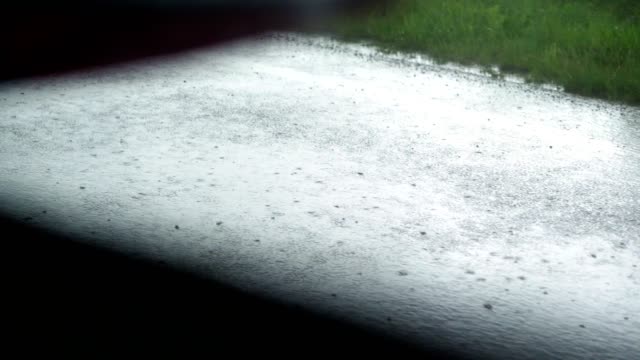 vista-desde-la-ventana-del-coche.-primer-plano,-orilla-de-la-carretera,-carretera,-en-la-lluvia,-mientras-el-coche-está-en-movimiento.-vista-desde-el-coche-en-una-carretera-mojada