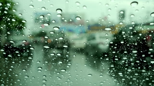 Windschutzscheibe-mit-Regen-fällt-während-stark-befahrenen-Innenstadt