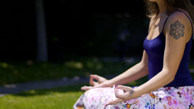 Outdoor-meditation-in-lotus-pose,-woman-sits-deeply-relaxed-feels-world-unity