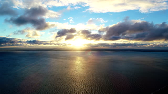 The-flight-above-the-water-on-the-sunset-background.-time-lapse