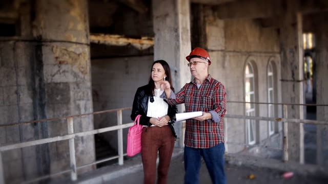 Female-Architect-and-foreman-on-the-site-of-construction-or-restoration,-discuss-the-construction-process-at-the-facility.