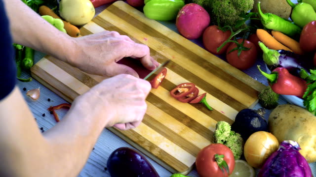 Der-Mensch-ist-Schneiden-von-Gemüse-in-der-Küche,-rote-Paprika-schneiden
