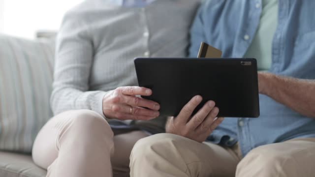 senior-couple-with-tablet-pc-and-credit-card