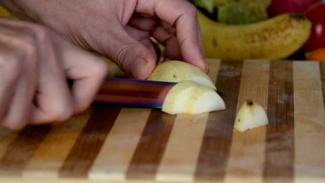 Man-is-cutting-pear-on-cutting-board