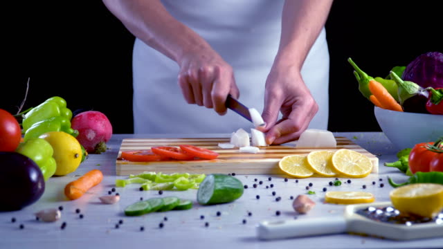 Man-is-cutting-vegetables-in-the-kitchen,-slicing-red-radish
