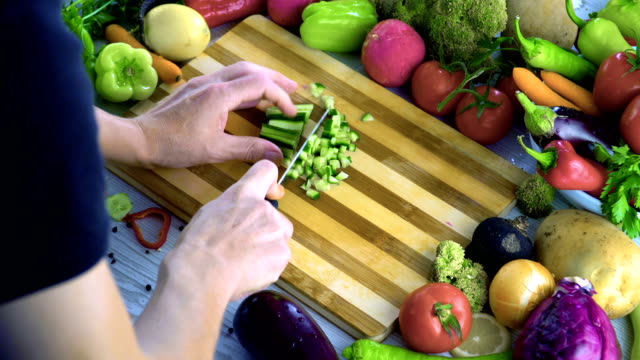 El-hombre-es-vegetales-de-corte-en-la-cocina,-cortar-el-tomate-en-cámara-lenta