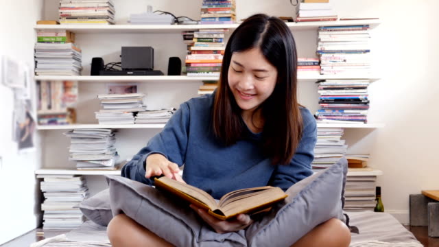 Libro-de-lectura-de-mujer-asiática-atractiva-en-su-habitación.-Personas-con-concepto-de-educación.