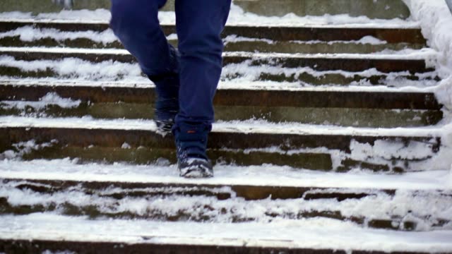 Boy-teenager-in-blue-down-jacket-lost-in-the-city.-He-goes-down-the-stairs.
