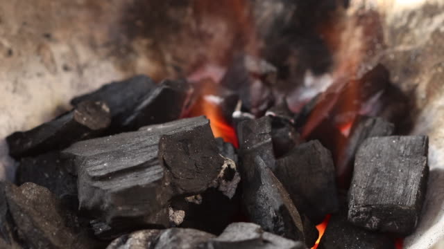 Flamme-aus-Feuer-Holzkohle-in-thai-traditionelle-Ofen-mit-Kiefer-Stick-lecken