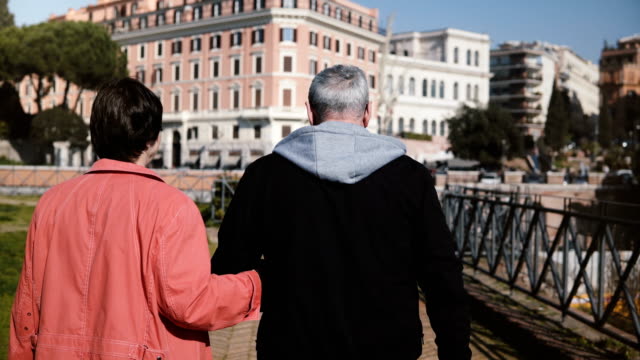 De-nuevo-vista-hermosa-romántica-senior-feliz-pareja-caminando-juntos-sosteniendo-las-manos-de-vacaciones-a-comienzos-de-otoño-Roma,-Italia.