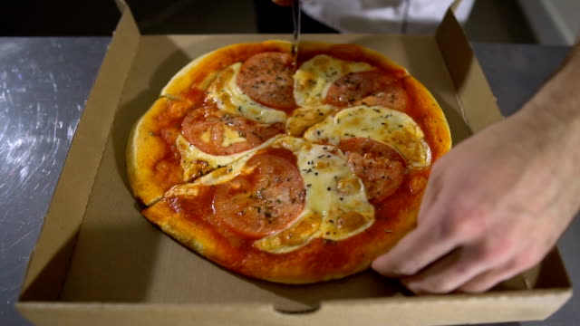 Mann-Chef-schneidet-die-köstliche-heiße-und-leckere-Pizza-hautnah
