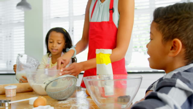 Schwarze-Mutter-mit-seinen-Kindern,-die-Zubereitung-von-Speisen-in-der-Küche-zu-Hause-4k