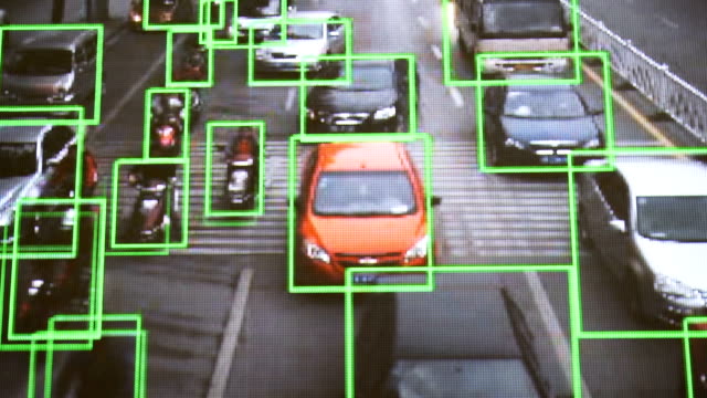 CCTV-Kamera.-Echtzeit-Verfolgung-von-Fahrzeugen-und-Menschen-auf-der-Straße.-Authentisches,-pixeliges-Bild-von-einem-realen-Monitor.