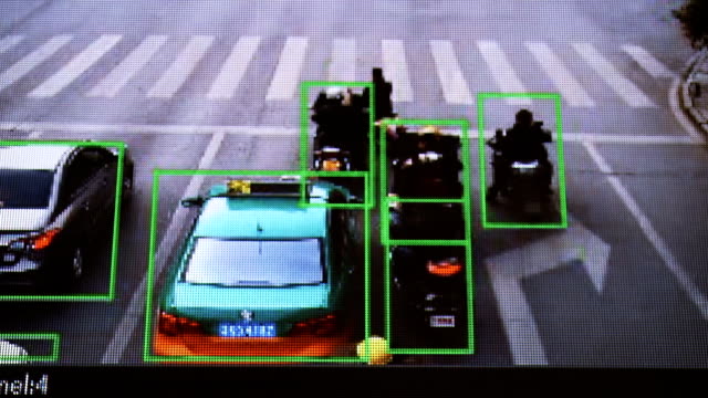 Cámara-CCTV.-Seguimiento-en-tiempo-real-de-vehículos-y-personas-en-la-calle.-Auténtica-imagen-pixelada-de-un-monitor-real.