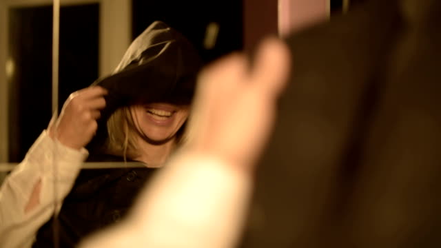 Close-up-of-a-girl-magician-in-front-of-a-mirror-puts-on-the-hood-of-his-suit-time-after-time.-Live-camera.