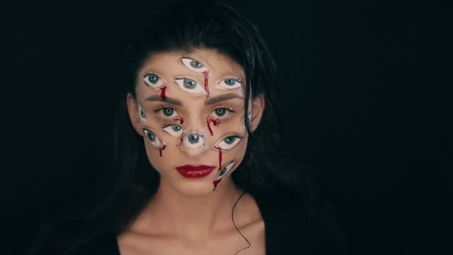 Kunst-Halloween-Make-up,-Frau-hat-viele-Augen-auf-ein-Gesicht