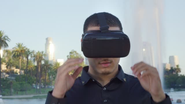 Junger-Mann-zieht-seine-VR-Brille-aus-und-schaut-in-die-Kamera