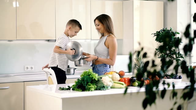 Kitchen-and-food.-Mom-and-son-are-holding-a-pot-for-cooking.