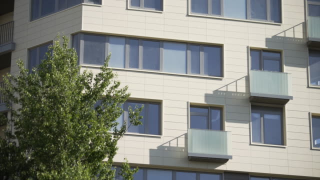 Neues-Fertighaus.-Wohnungen-in-Plattenhäusern.-Die-Fassade-eines-modernen-Wohngebäudes-mit-Balkonen-und-Fenstern,-nahaufnahme.-Viele-neue-Böden