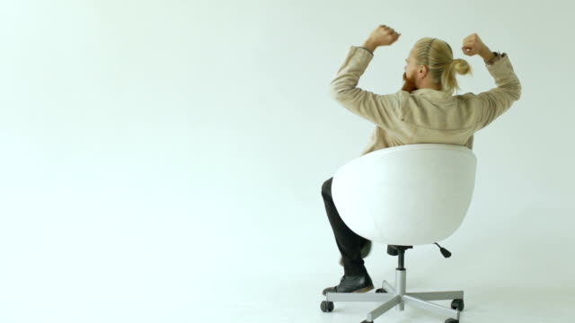Slowmotion-of-Bearded-businessman-have-fun-turning-on-office-chair-on-white-background