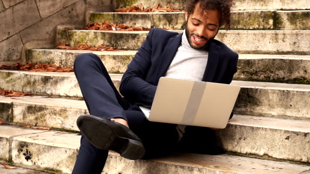 businessman-lying-on-steps-with-laptop