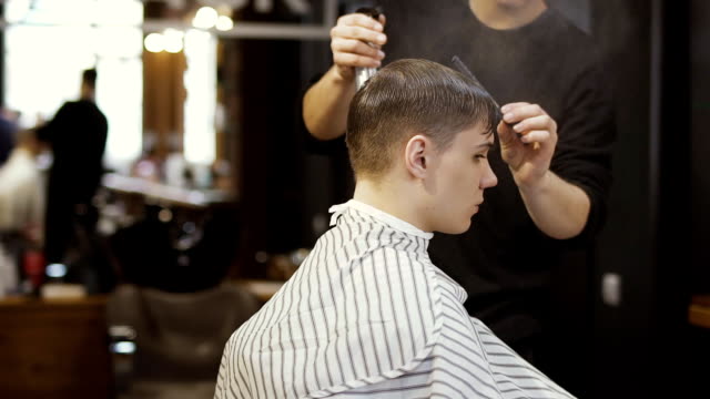 Professionelle-Friseur-macht-einen-stylischen-Haarschnitt-für-jungen-Kerl
